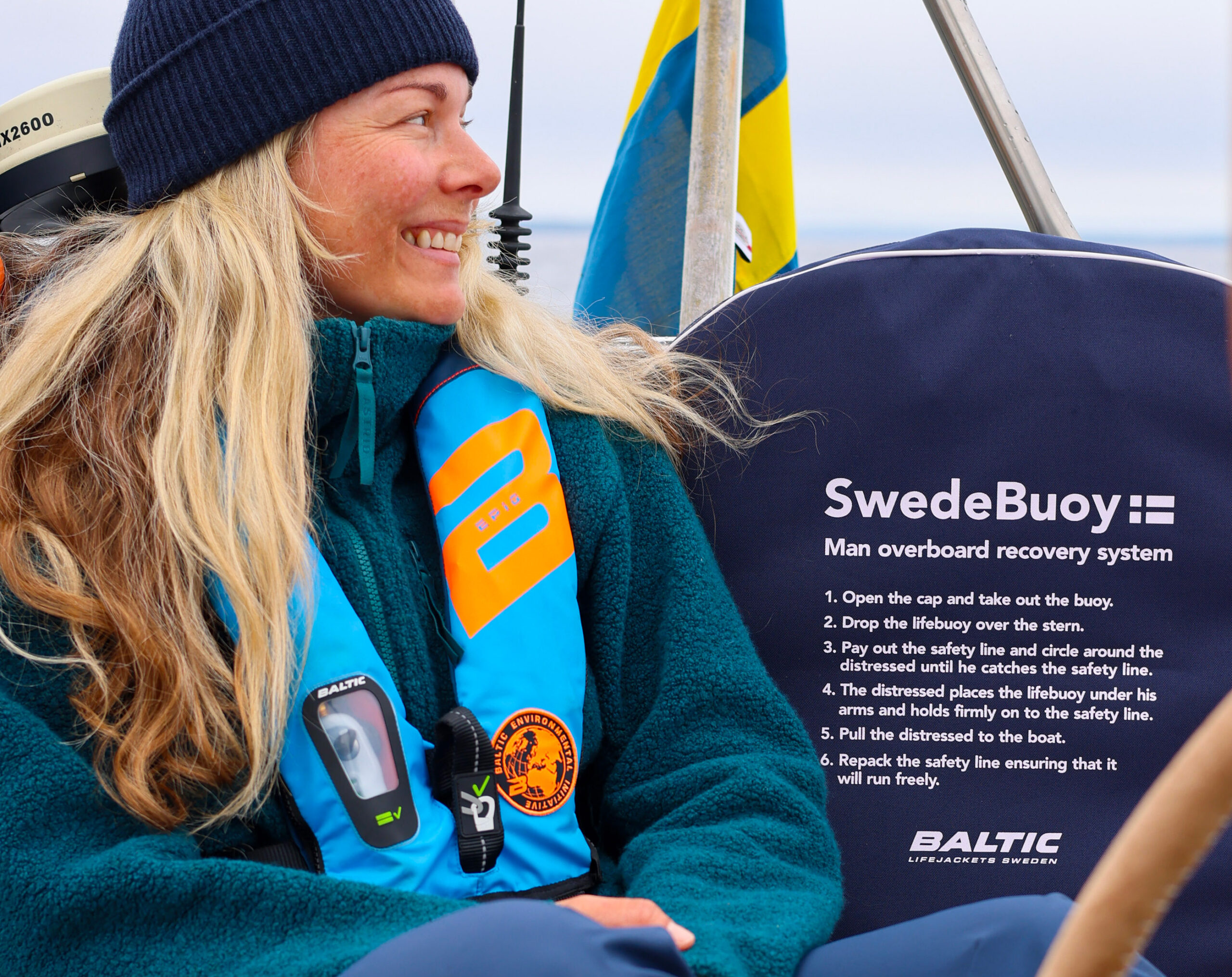 En kvinna sitter på en segelbåt och tittar ut.